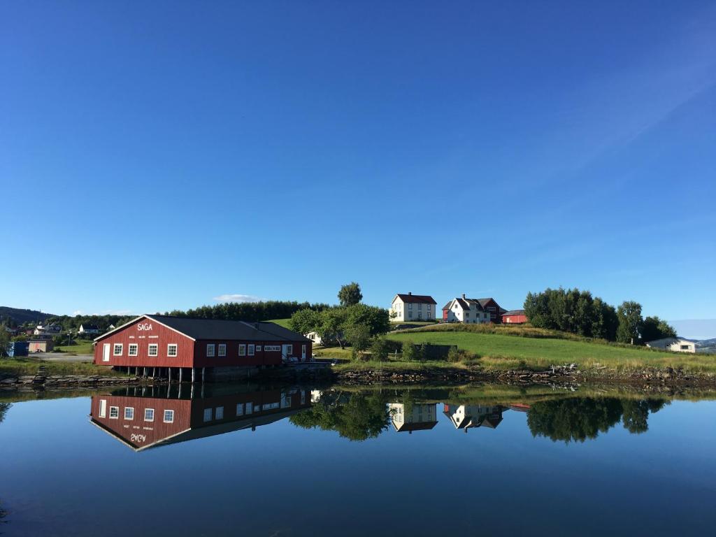 Straumen的住宿－SAGA, badehotell med sauna og badebrygge - Inderøy，水体岸边的房子