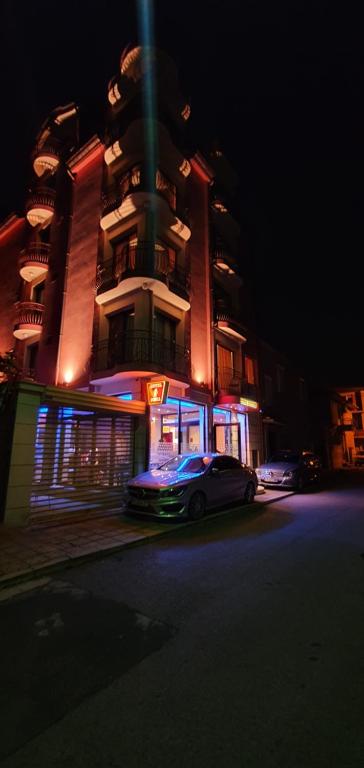 ein Auto, das nachts vor einem Gebäude parkt in der Unterkunft Sofia Family Hotel in Pomorie