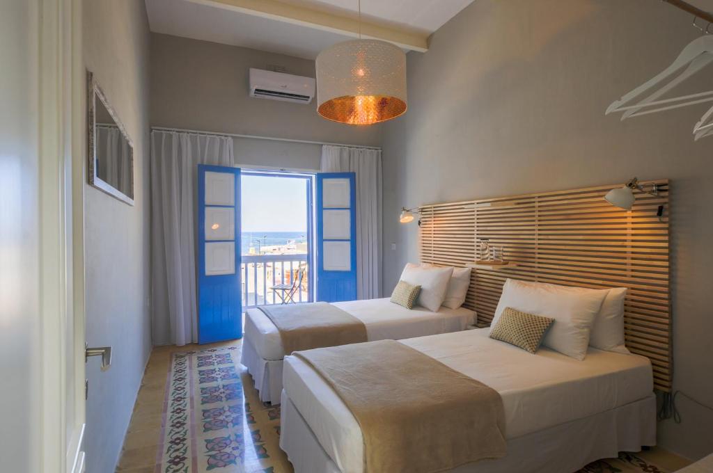 a hotel room with two beds and a window at Number 28 - The house with the blue door in Żebbuġ