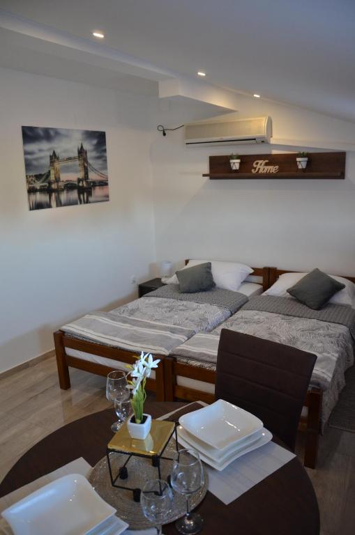 una habitación con 2 camas y una mesa con sidra de mesa en Apartman Dabrović, en Novska