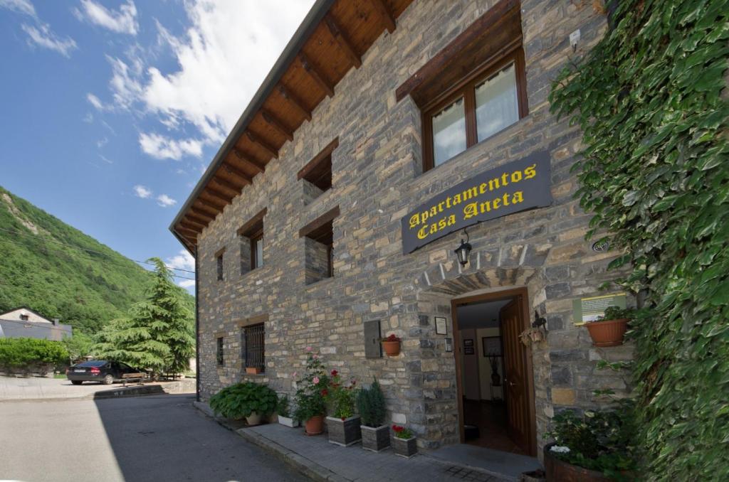 un edificio de piedra con un cartel en el costado en Apartamentos Casa Aneta, en Sarvisé