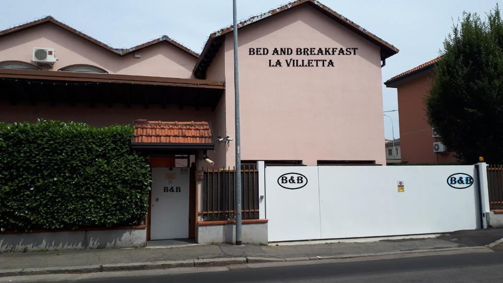 - un bâtiment avec un panneau indiquant le bar et le petit-déjeuner la villaria dans l'établissement Ciro BED AND BREAKFAST la villetta, à Pioltello