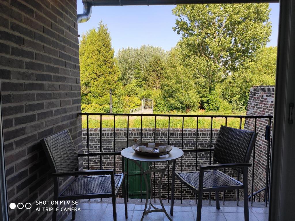 een patio met een tafel en stoelen op een balkon bij LE CANGE in Amiens