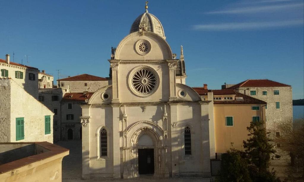 an old building with a clock tower in a city at Apartman Cathedral in Šibenik