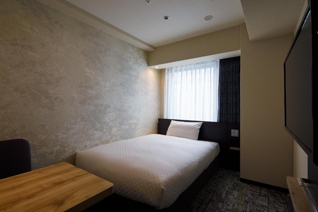 Postel nebo postele na pokoji v ubytování Via Inn Prime Kyotoeki Hachijoguchi