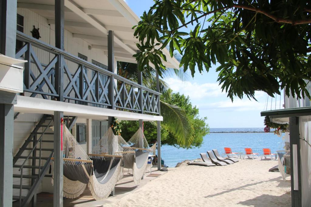 a resort with chairs and hammocks on the beach at Coral Reef Beach in Savaneta