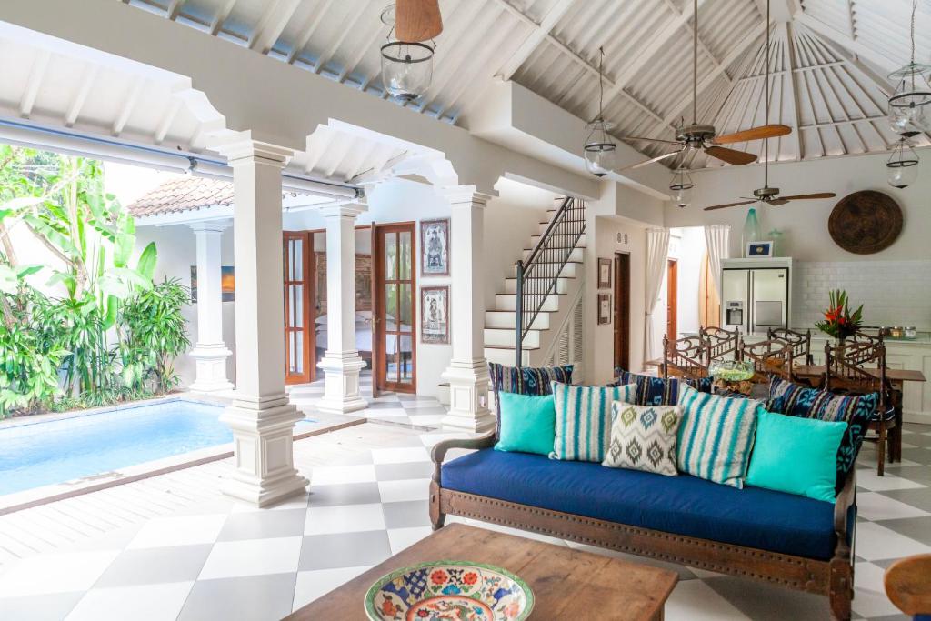 a living room with a blue couch and a pool at Villa Seni in Seminyak