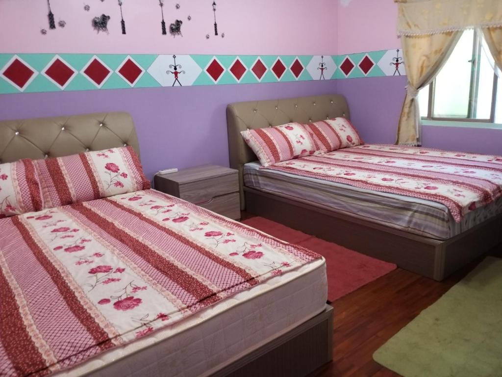 2 łóżka w pokoju z fioletowymi ścianami w obiekcie Fu Ya N B&B w mieście Lanyu