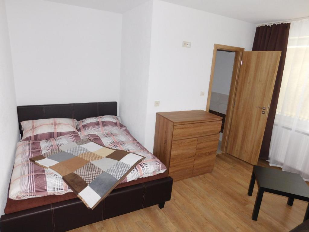 1 dormitorio con cama, tocador y espejo en Ubytovanie u Albína, en Betlanovce