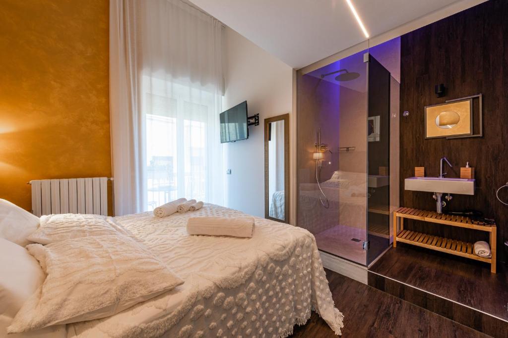 a bedroom with a large bed and a shower at Sinestesia in Polignano a Mare