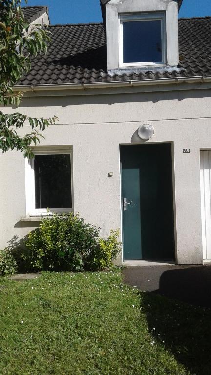 une maison blanche avec une porte verte sur elle dans l'établissement Foreword House, à Albert