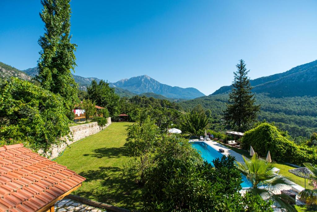 a resort with a swimming pool and mountains in the background at Lycia Nature House in Cıralı