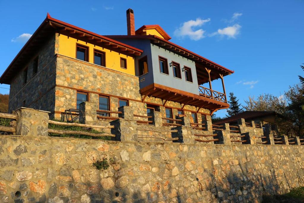 un edificio en la parte superior de una pared de piedra en Casa Kedrova, Mountain Voras-Kaimaktsalan Edessa, en Kedhróna