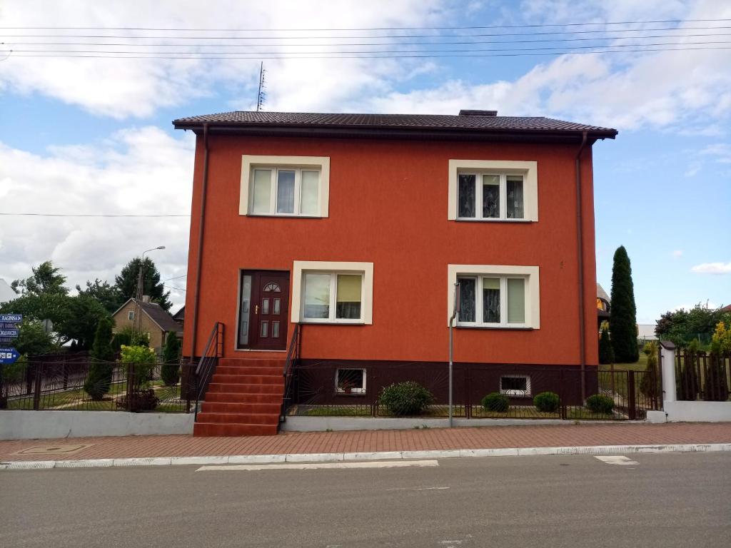 a red house on the side of a street at U Wileńskich in Wizna
