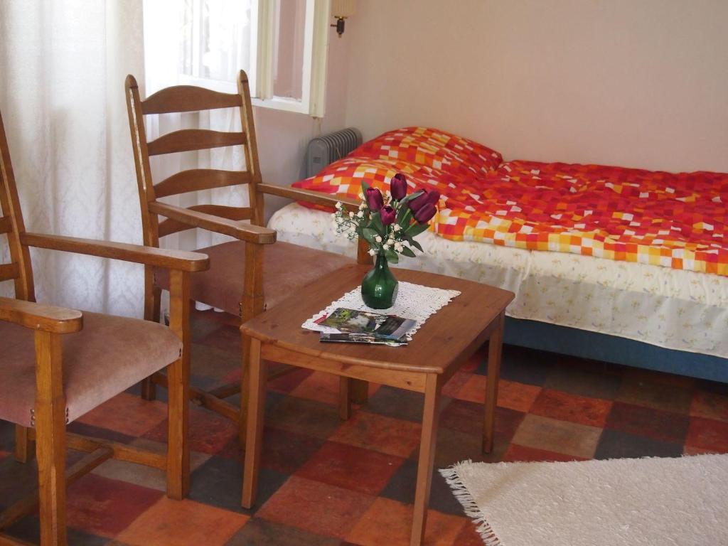 a room with a table and chairs and a bed at DéeL apartman in Nyíregyháza