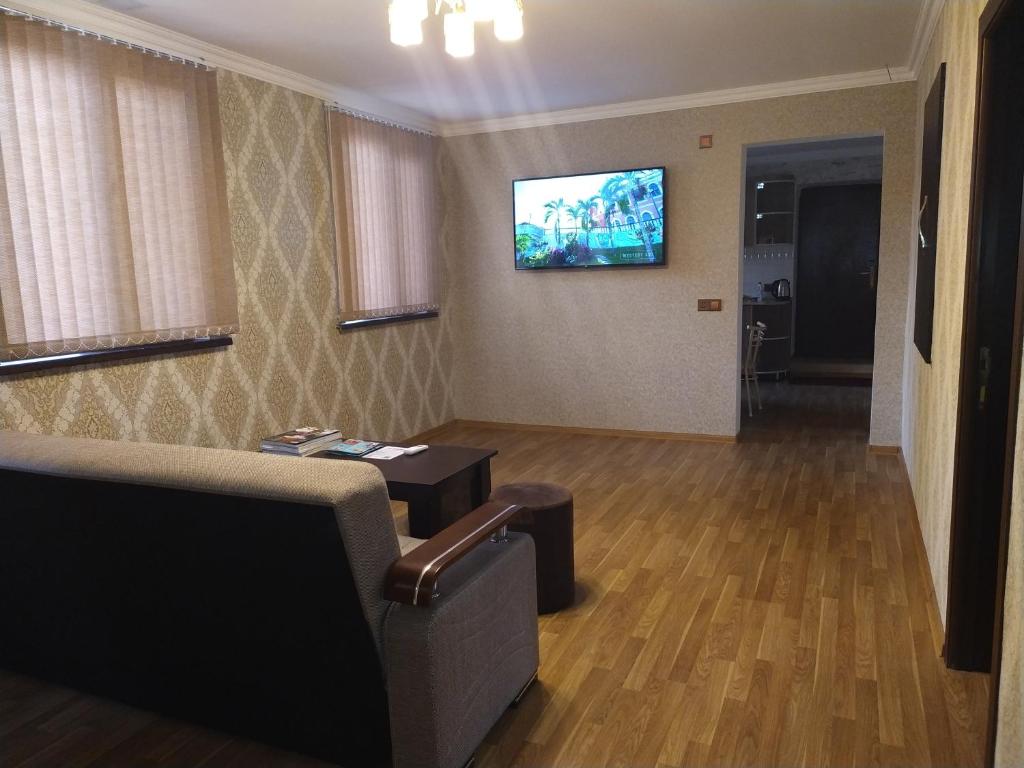 - un salon avec un canapé et une télévision murale dans l'établissement Ganja Apartment, à Gandja