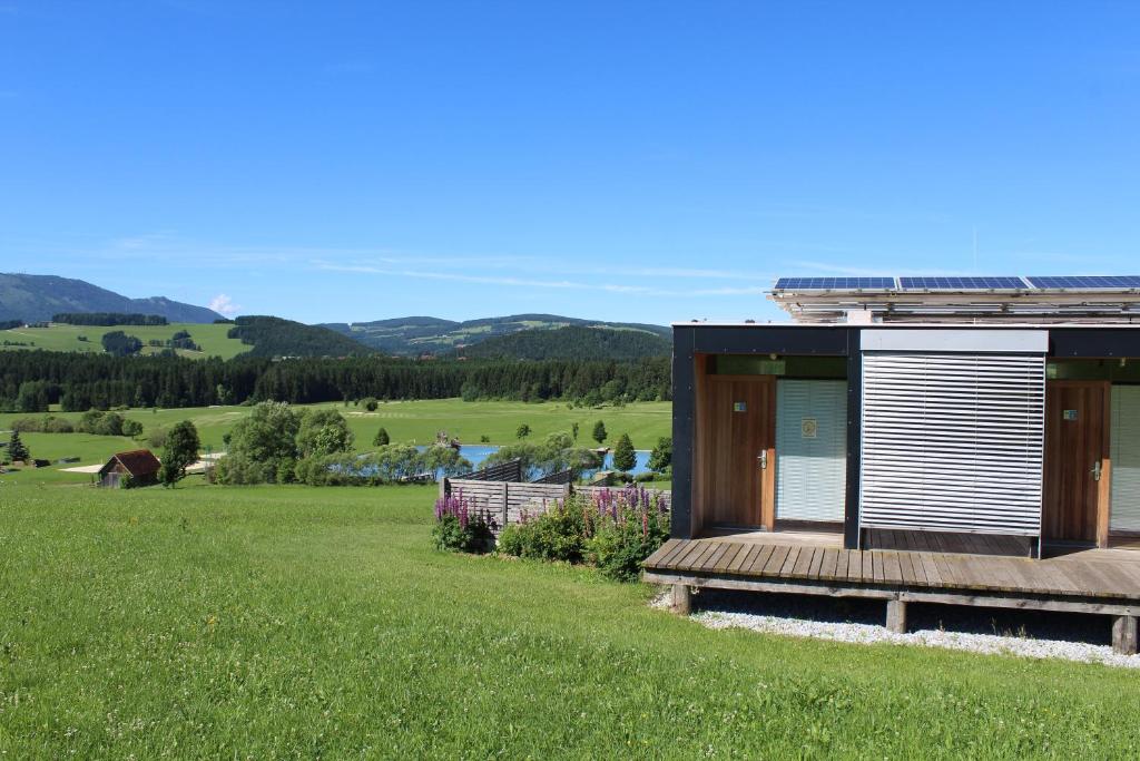 une maison avec une terrasse sur une pelouse dans l'établissement Almenland Apartment Passail, à Passail