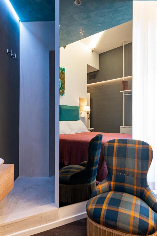 a bedroom with a bed and two comfortable chairs at Sinestesia in Polignano a Mare
