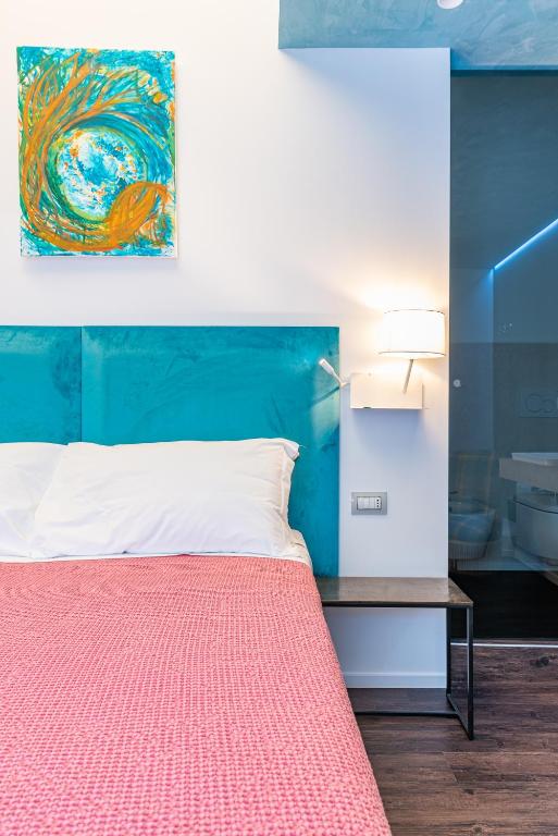 a bedroom with a bed and a painting on the wall at Sinestesia in Polignano a Mare