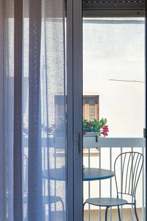 a table and chairs on a balcony with a window at Sinestesia in Polignano a Mare