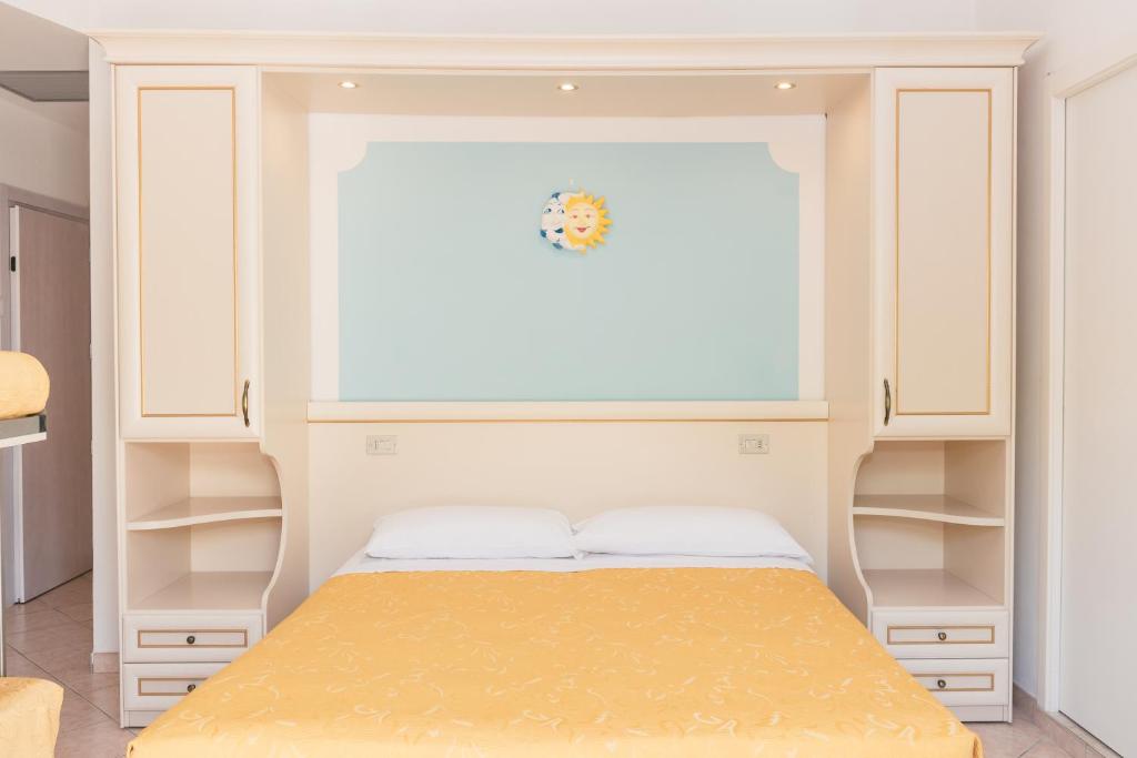 sypialnia z łóżkiem z oknem i półkami w obiekcie Hotel Altair w mieście Misano Adriatico