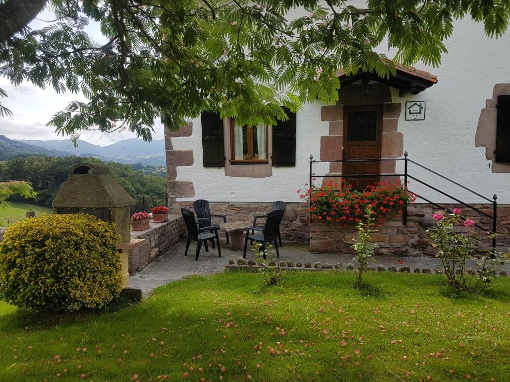 una casa con sillas y una mesa en el patio en Casa Rural Petisansenea II, en Zuaztoy de Azpilcueta