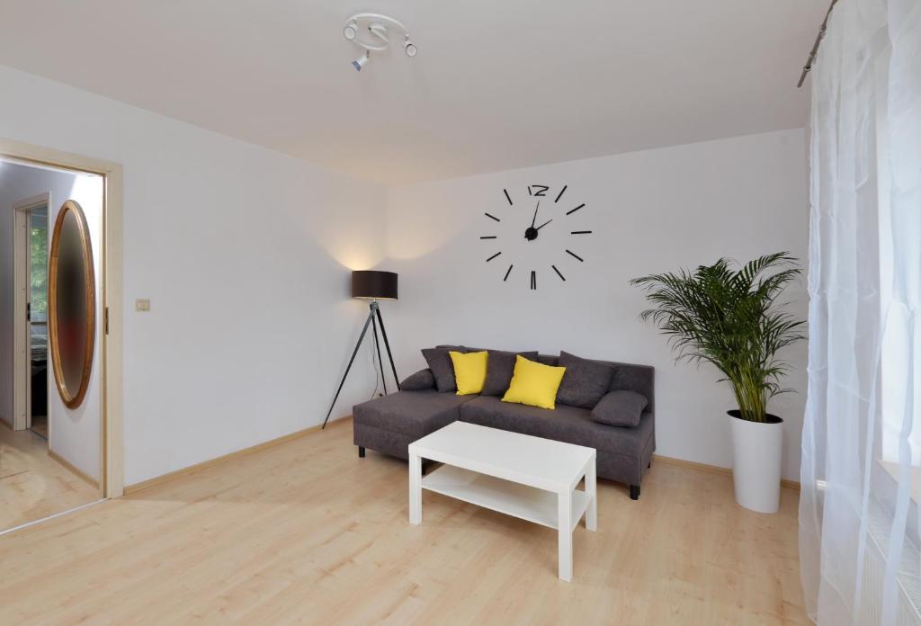 a living room with a couch and a clock on the wall at Apartament Słoneczny 3 in Opole