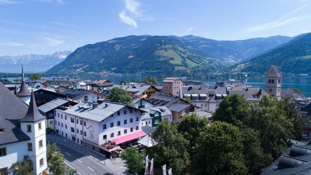 Vistas a una ciudad con montañas en el fondo en Hotel Steinerwirt1493, en Zell am See