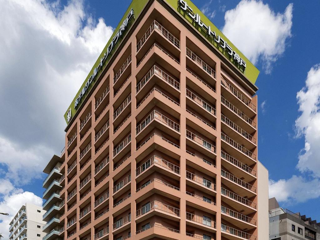 a tall building with a sign on top of it at Hotel Sunroute Sopra Kobe in Kobe