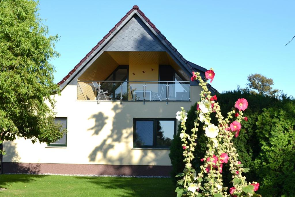 a house with a balcony and flowers in front of it at Ferienhaus Saupe in Schaprode