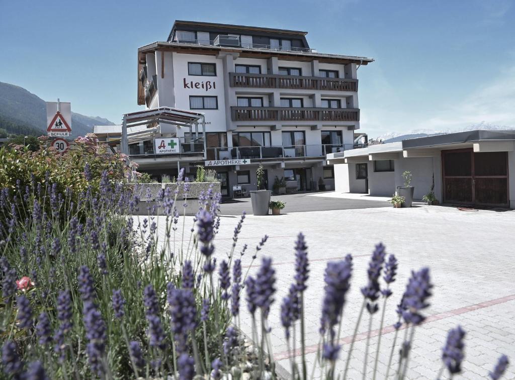 un edificio con fiori viola di fronte di Hotel Kleißl a Oberperfuss