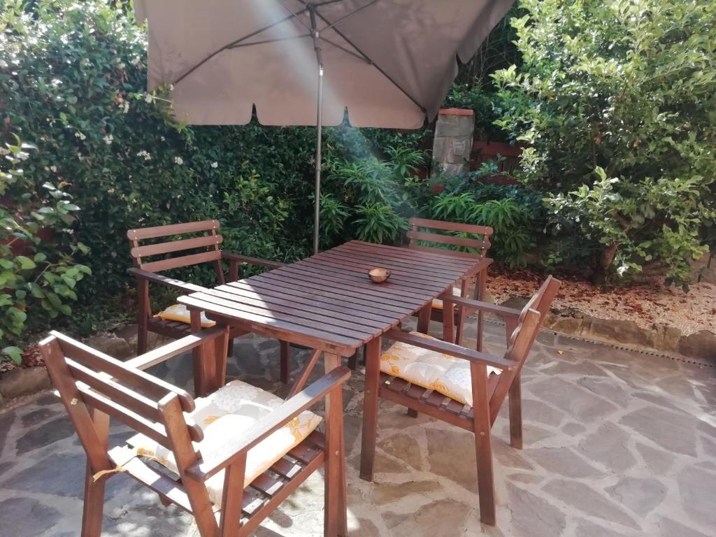 a wooden table with two chairs and an umbrella at Il mulino in Beverino