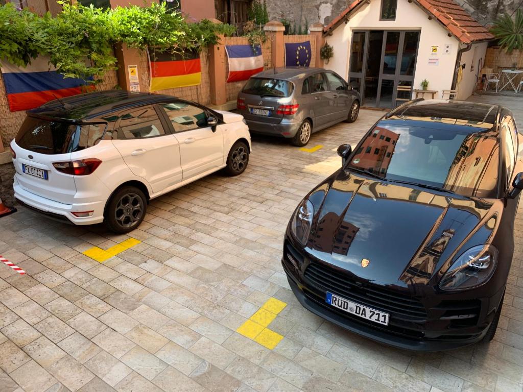 dois carros estão estacionados num parque de estacionamento em Affittacamere Virginia's Rooms em Génova