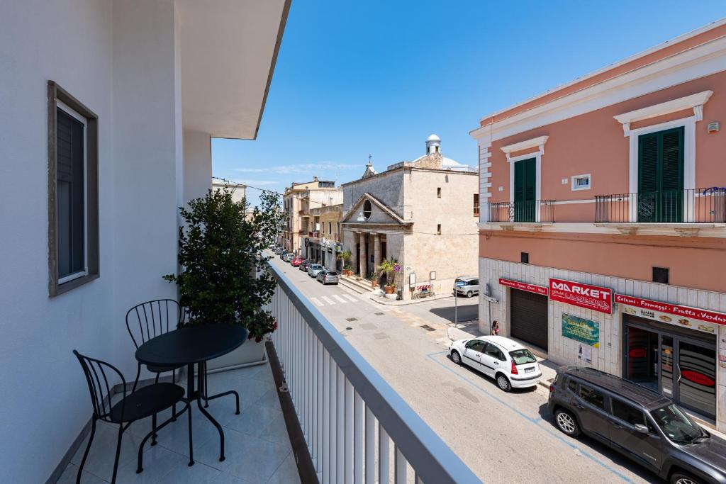 a balcony with a table and chairs on a city street at Sinestesia in Polignano a Mare