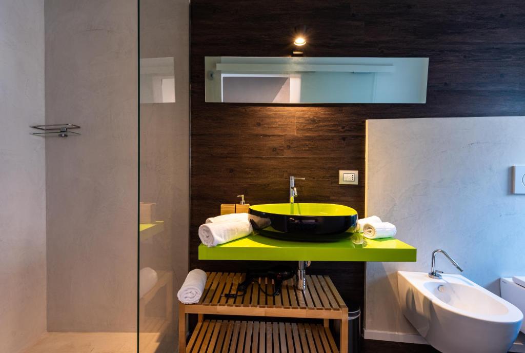 a bathroom with a yellow sink and a tub at Sinestesia in Polignano a Mare
