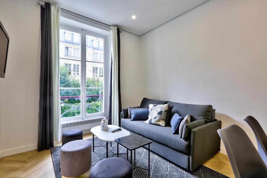 a living room with a couch and a window at 92 - Beautiful Apartment in Montorgueil in Paris