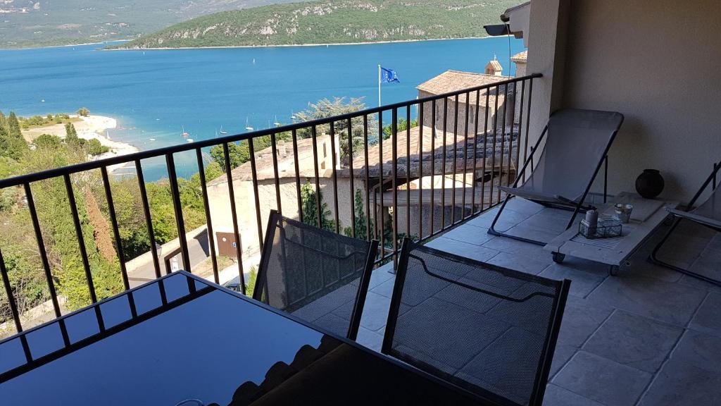 een balkon met een tafel en stoelen en de oceaan bij La Frache in Sainte-Croix-de-Verdon