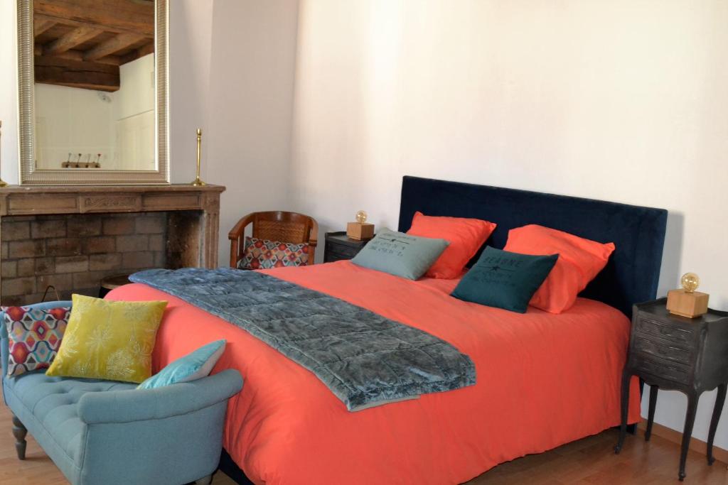 una camera con letto rosso, sedia e specchio di Dolce Vita a Chalon-sur-Saône