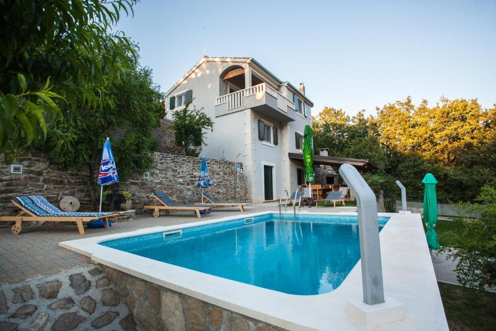 eine Villa mit einem Pool und einem Haus in der Unterkunft Villa Eagle in Svinišće