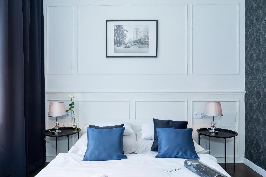 a bedroom with a white bed with blue pillows at Zwierzyńscy Residence 2 in Pobierowo