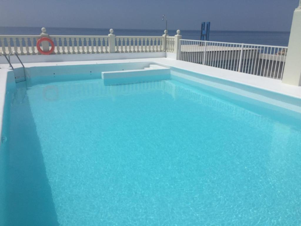
a white swimming pool with a blue railing at Urban Beach Torrox Costa in Torrox Costa

