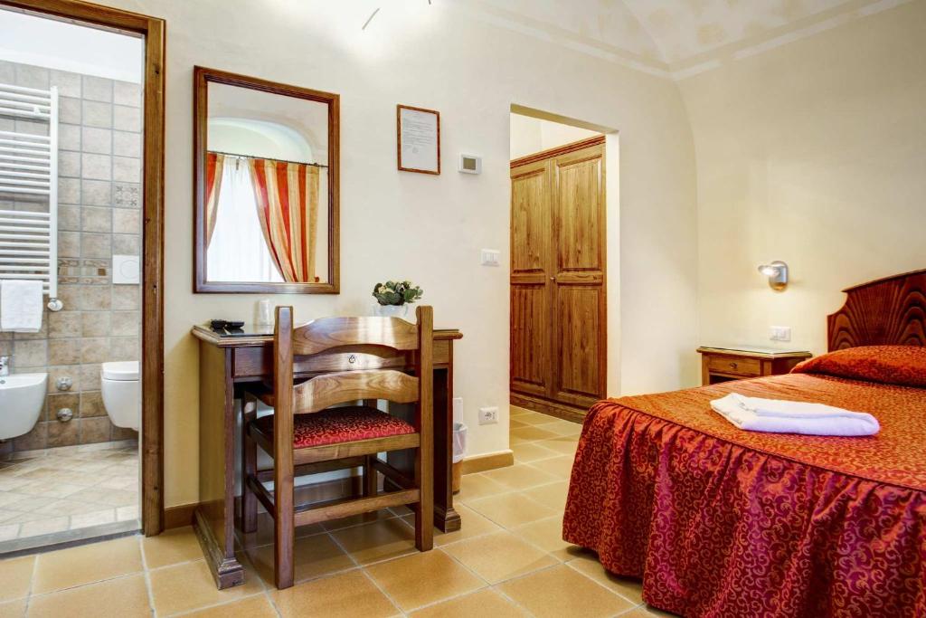 sypialnia z łóżkiem oraz łazienka z umywalką w obiekcie Hotel Residence Villa Rioddi w mieście Volterra