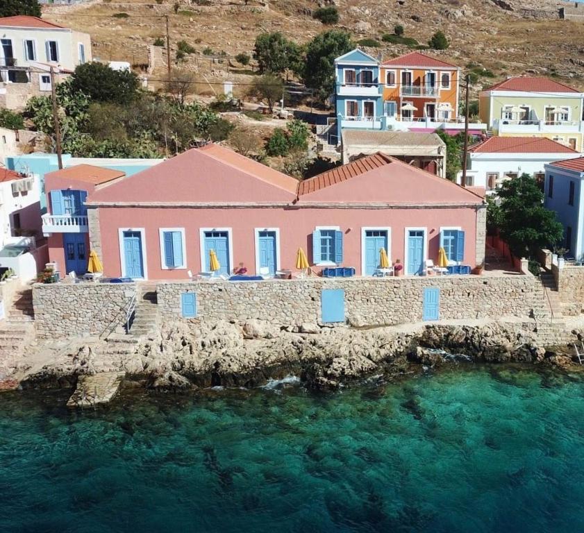 a house on a cliff next to the water at Villa Hiona in Halki