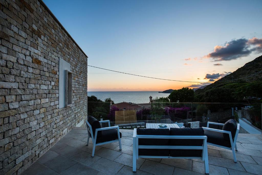 a patio with a view of the ocean at sunset at Scissure Sea Suite in Gaeta