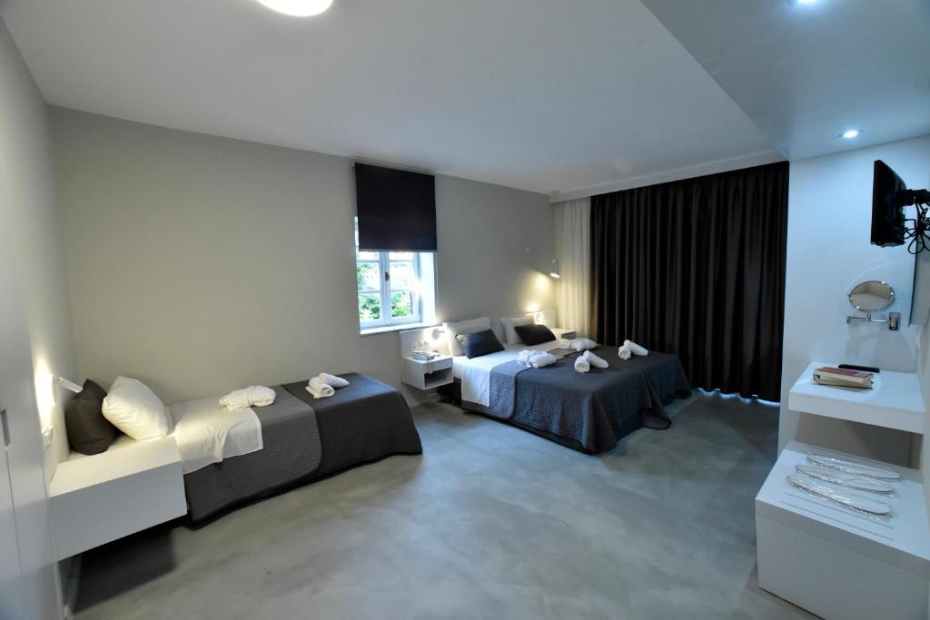 A bed or beds in a room at Olive Press Hotel & Apartments
