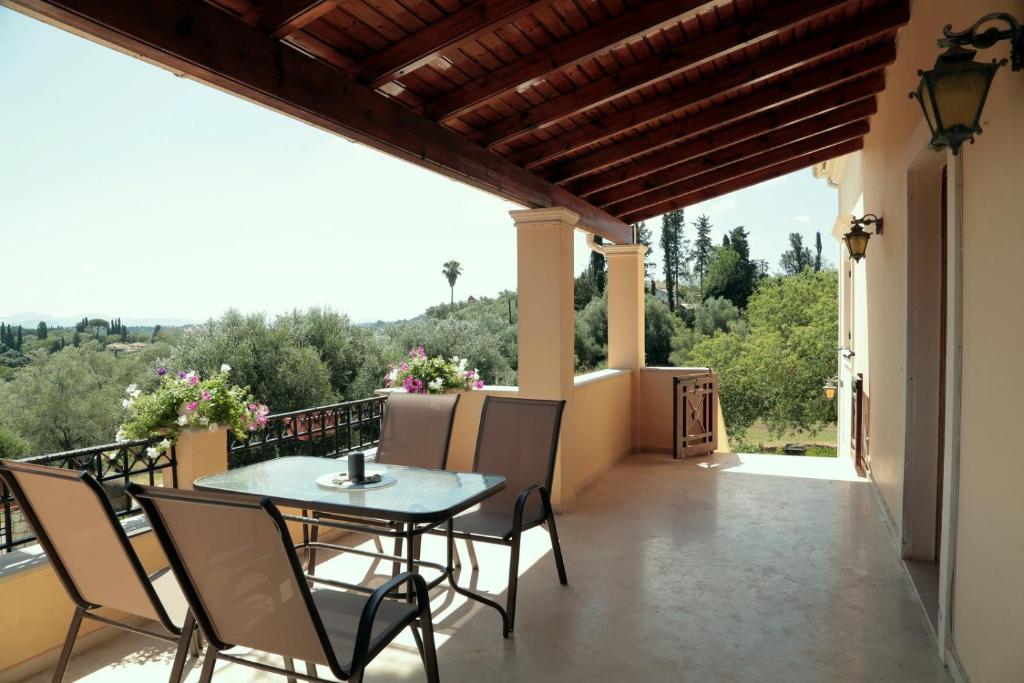 um pátio com uma mesa e cadeiras numa varanda em Zen House Corfu em Ágios Ioánnis