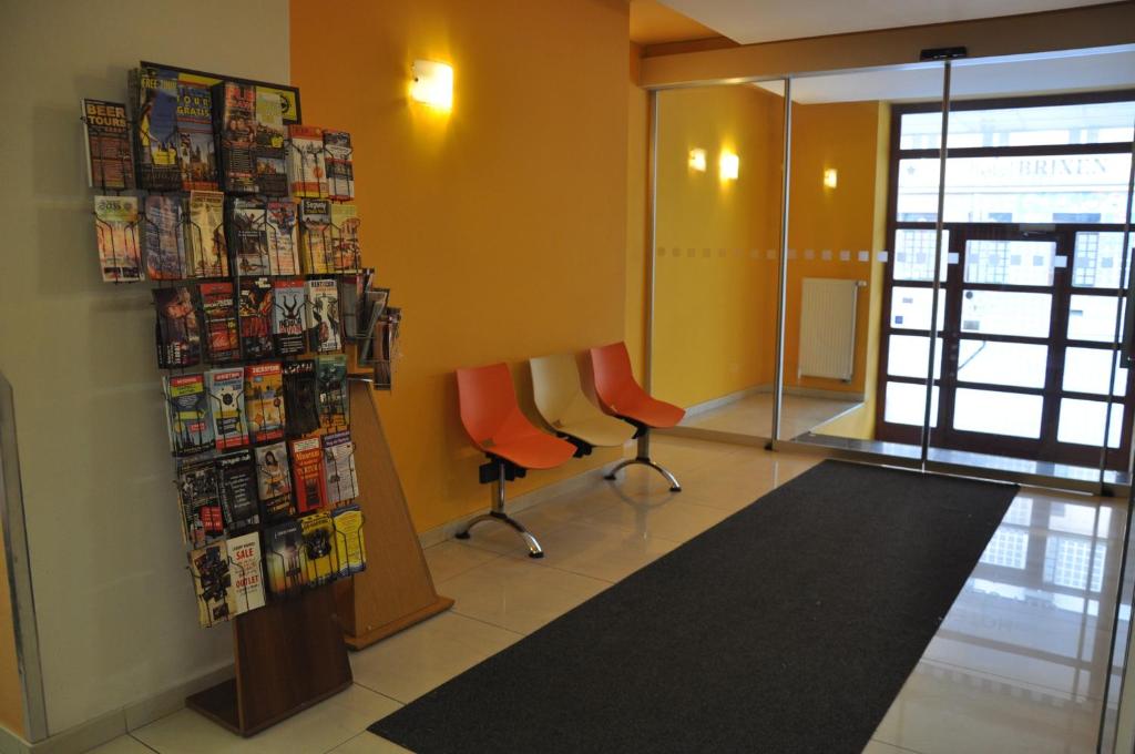 a waiting room with two orange chairs and magazines at City Central De Luxe in Prague