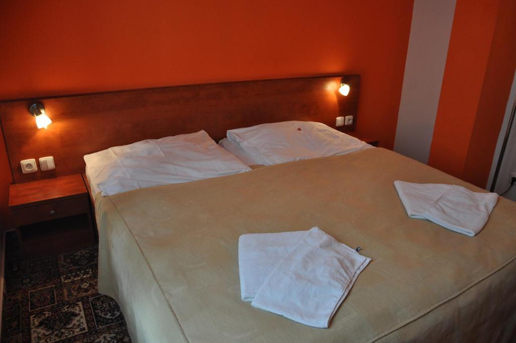 a bedroom with a bed with two white towels on it at City Central De Luxe in Prague