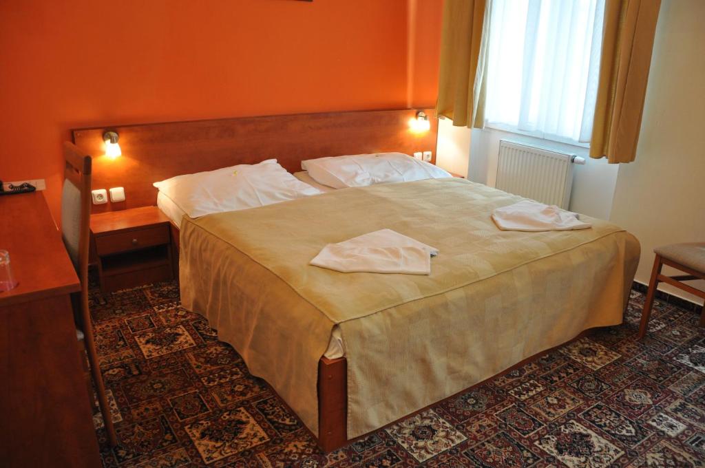 a hotel room with a bed with two towels on it at City Central De Luxe in Prague