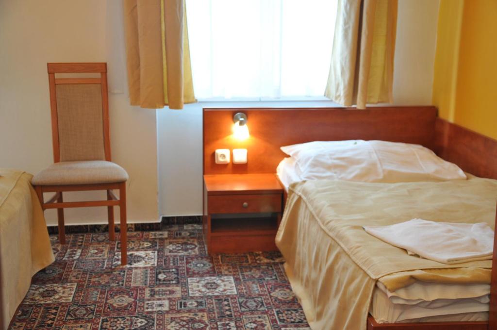 a bedroom with a bed and a chair and a window at City Central De Luxe in Prague